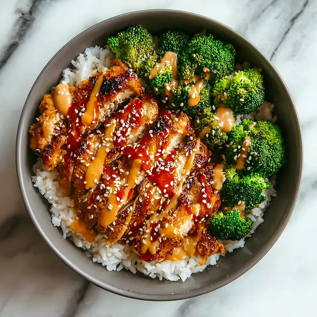 A bowl of food with rice, broccoli, and chicken.